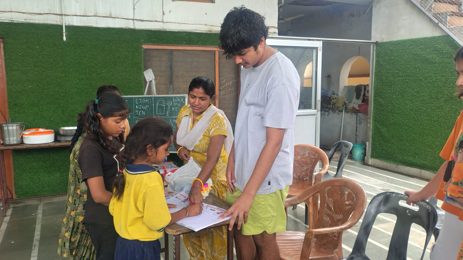 Kandarp helping students with a worksheet during a Project Udaan session